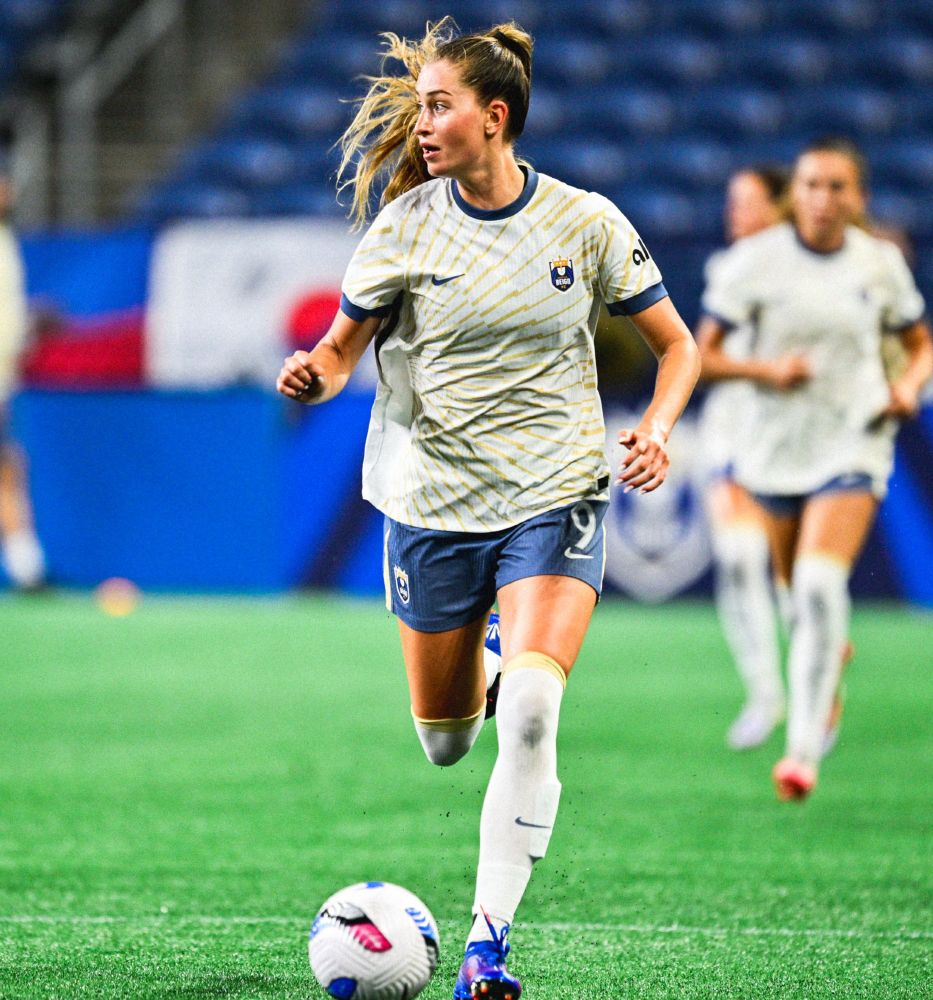 Jordyn Huitema runs up the field with the ball at her feet