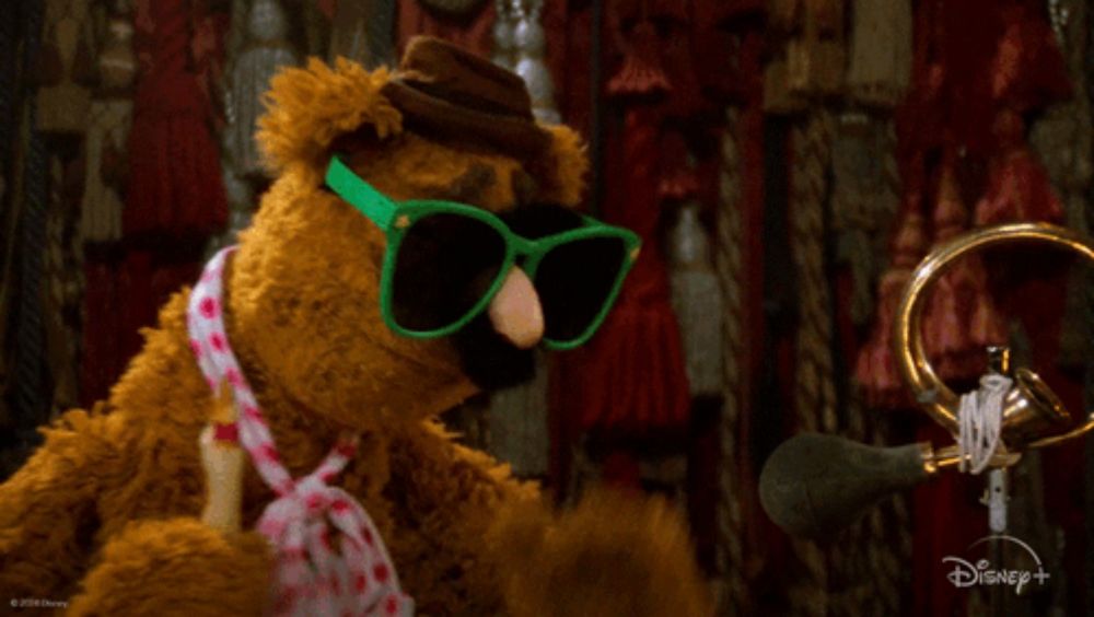 a stuffed animal wearing green sunglasses says wocka