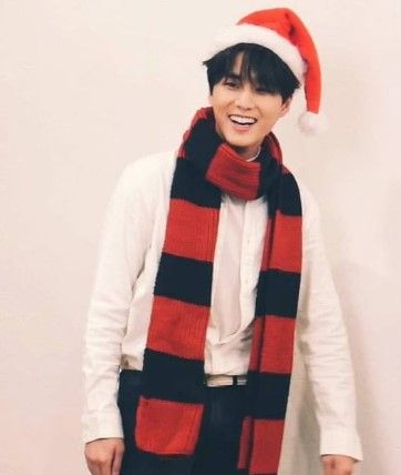 Day6's Young K wearing a red and black scarf and a santa hat