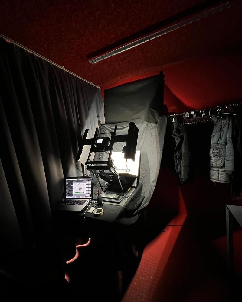 Een donkere foto van de fotostudio van de Digital Manuscript Nomads in een garderobe met rode muren.