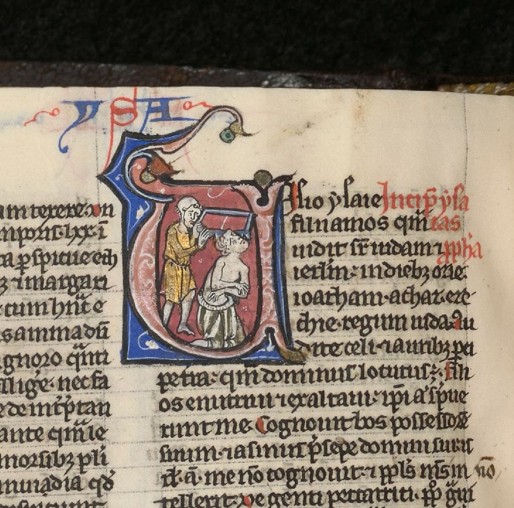 Een middeleeuws manuscript met een versierd initiaal waarin door het hoofd van een man gezaagd wordt door een droevig uitziende man.