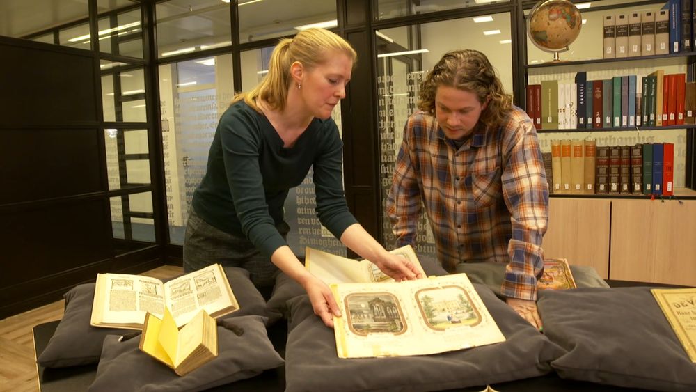 Karin en Pascal kijken naar een kinderboek met bewegende delen. 