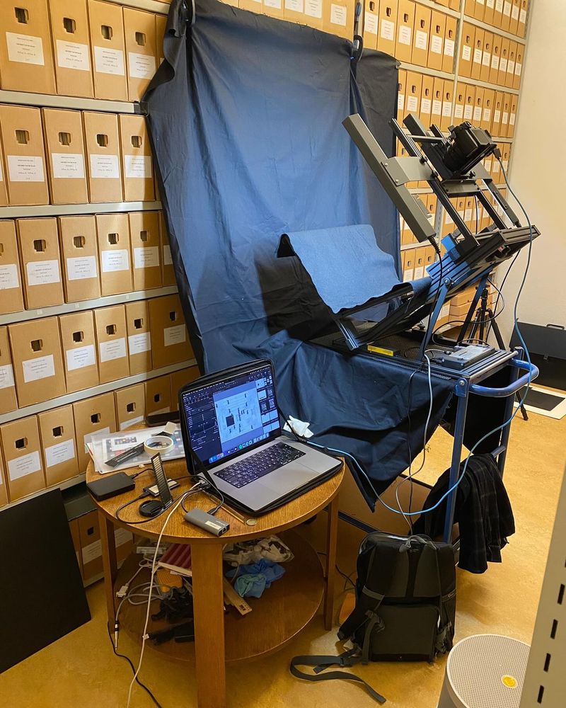De fotostudio van de Digital Manuscript Nomads in een opslagruimte vol kartonnen documentdozen.