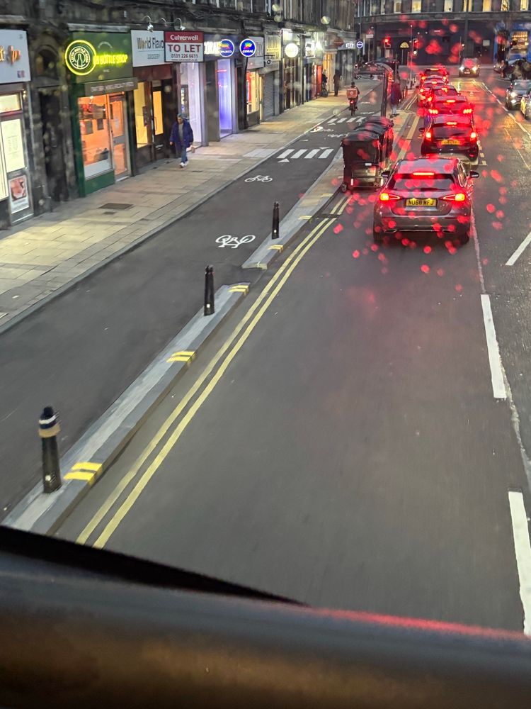 An on street curb and bollard separated bike way on a street in Leith 