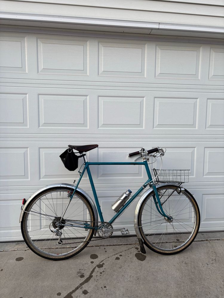 A blue upright bike leaned against a garage door
