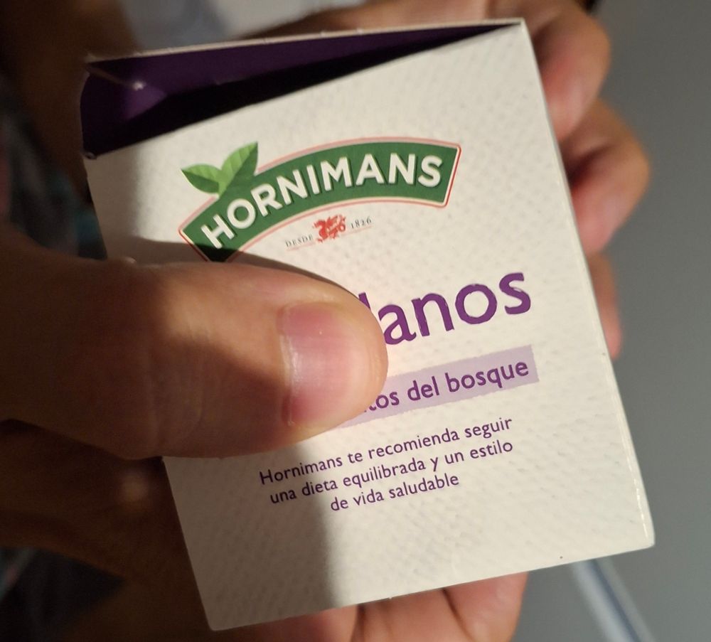 Infusión de arándanos con frutos del bosque a la que con un dedo han tapado arand para que ponga anos