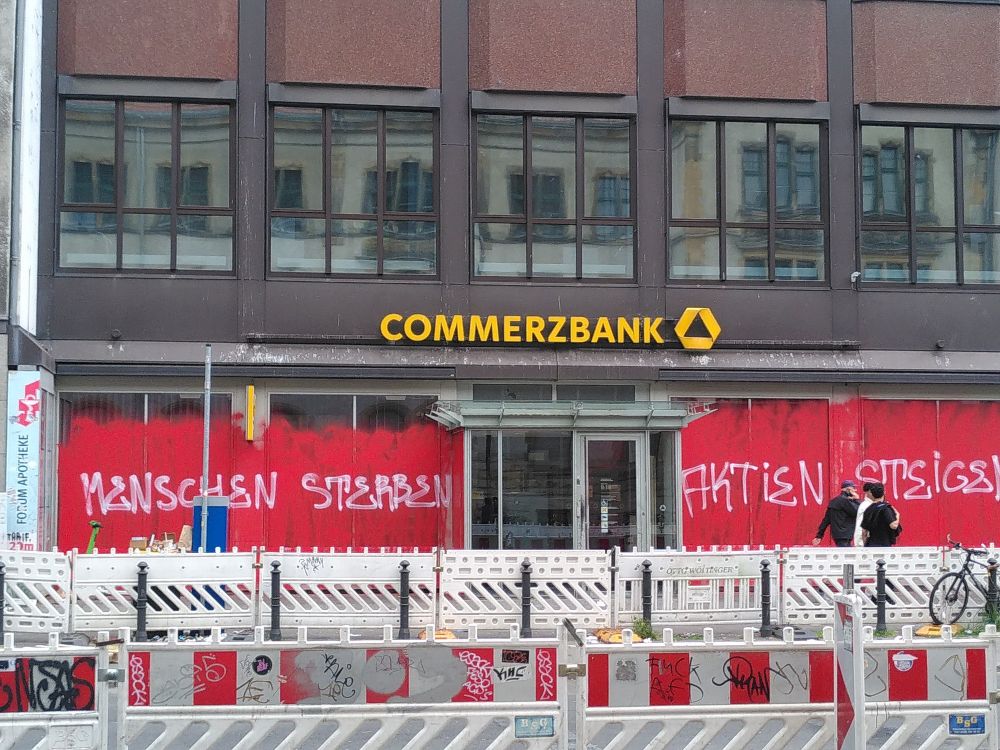 Commerzbank Filiale ist mit dem Spruch besprüht "Menschen sterben, Aktien steigen"