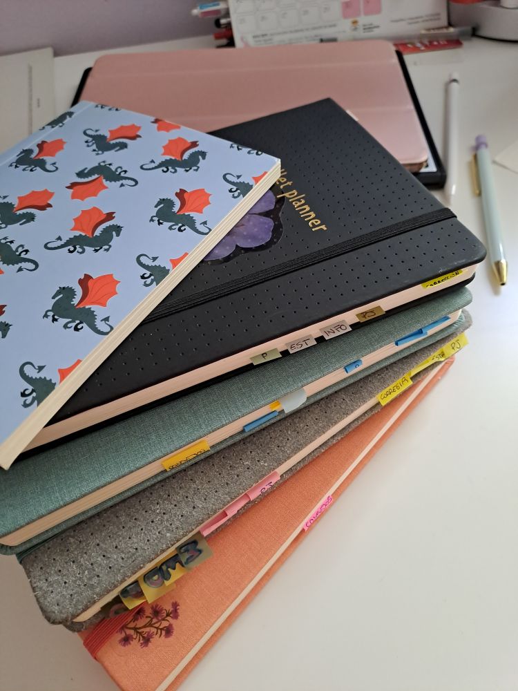 6 cuadernos apilados con posit entre las paginas