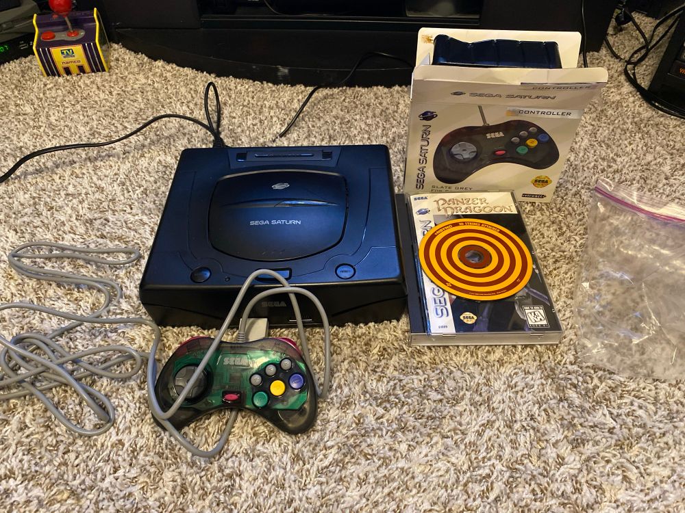 A Sega Saturn console, hooked up with a copy of Panzer Dragoon and an *NSYNC No Strings Attached audio disc.