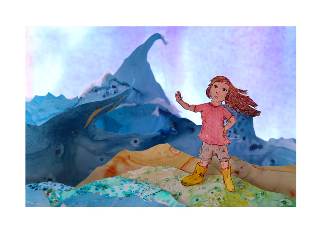 Girl standing on some rocks beside a rough seascape . Diorama image