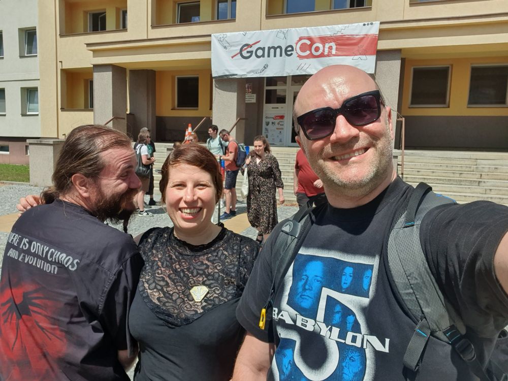 Three Babylon 5 fans outside taking a selfie while wearing B5 merch.