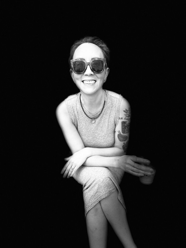 Black and white portrait of a smiling woman in sunglasses