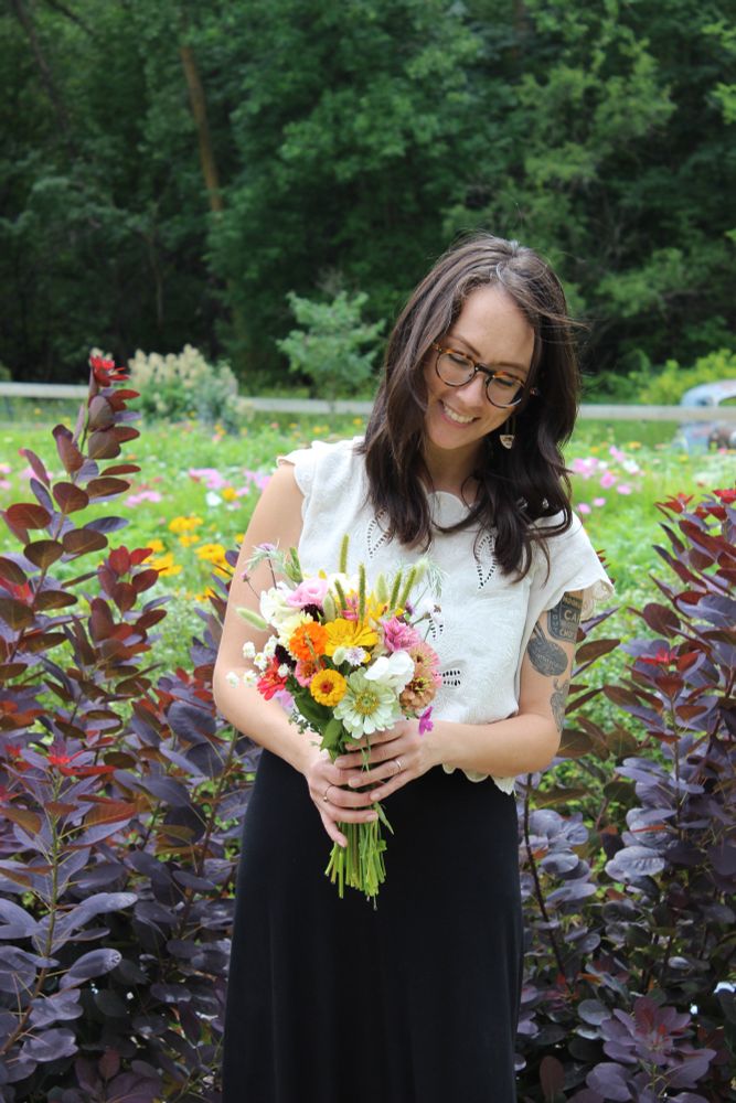 A smiling woman holding a bouquet of flowers. 