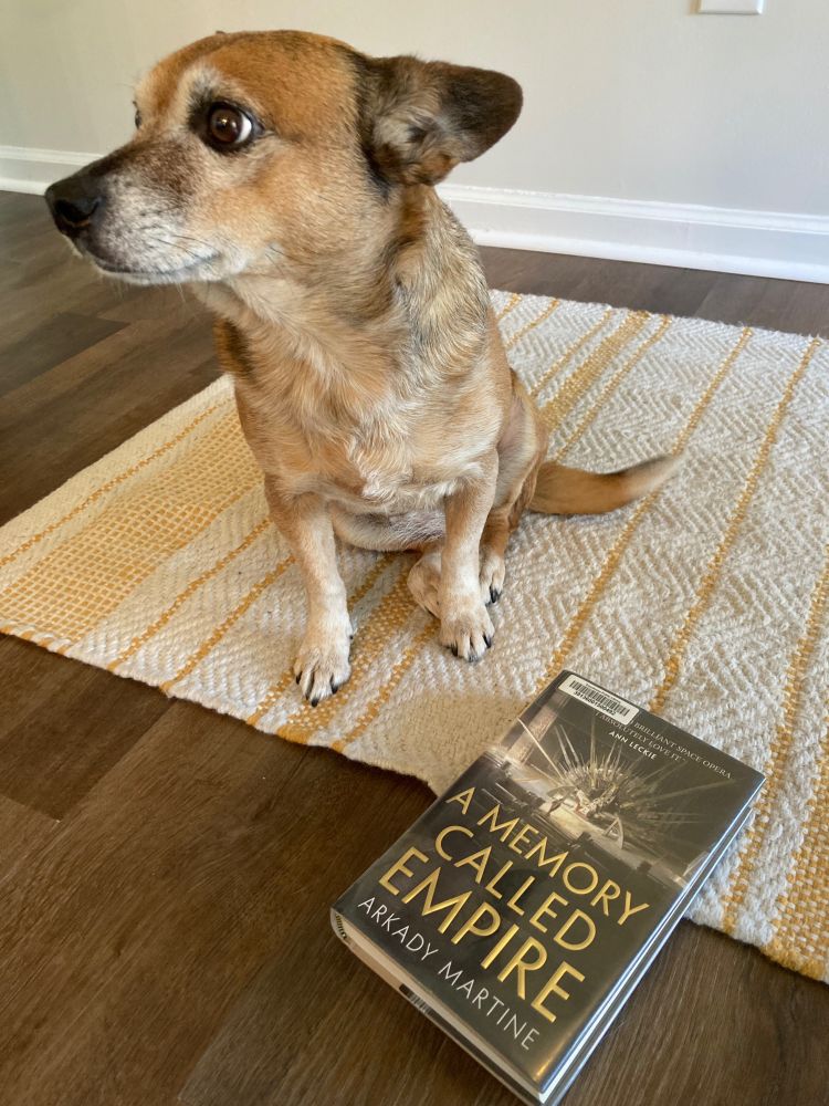 A charming, noble-hearted dog and the book A Memory Called Empire by Arkady Martine