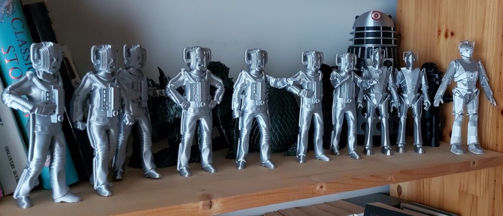 10 shiny silver 3d printed Cybermen from the Dr. Who tv series on a shelf