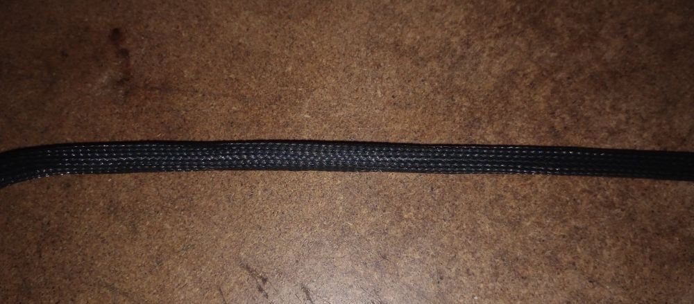 Picture of a braided cable sleeve over a valve index tether cable. The cable sleeve is well fitted to he cable with minor variations in "tightness" on the cable