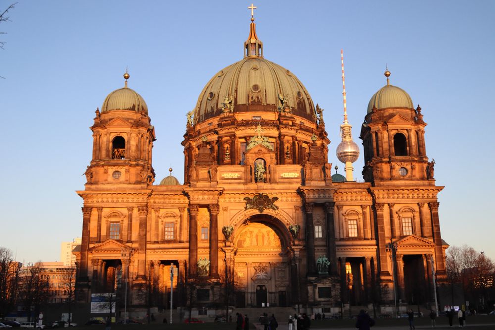 Berlin TV tower visible through a gap between towers of the French cathedral.