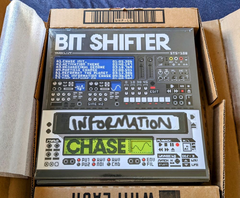 Photo of a small stack of shrinkwrapped 12" vinyl records in an opened cardboard box, the last of the Bit Shifter: Information Chase pressing.