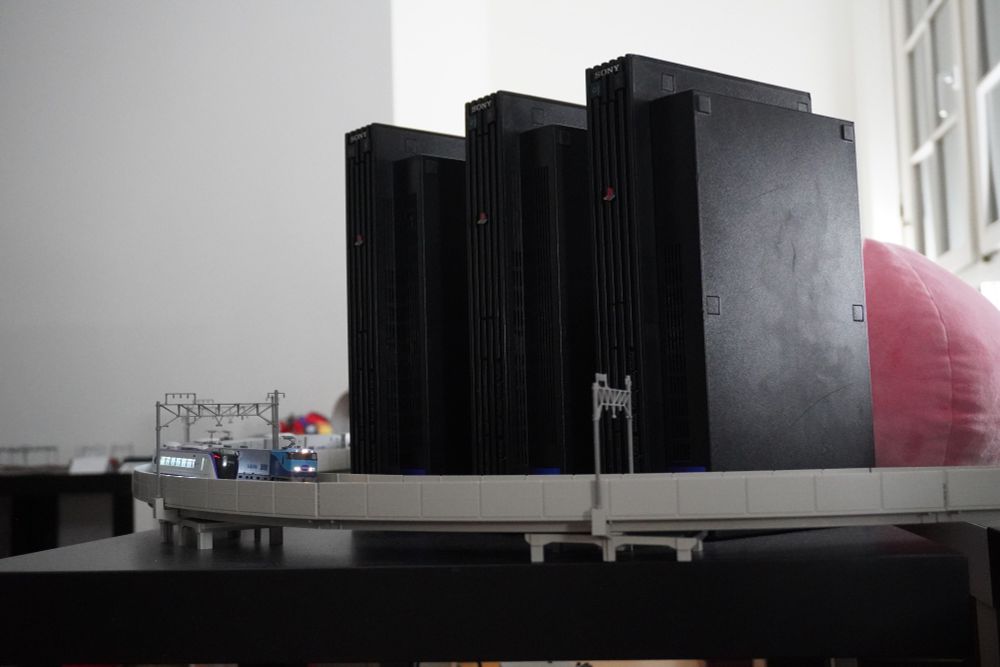 Model trains in front of buildings made out of PS2s