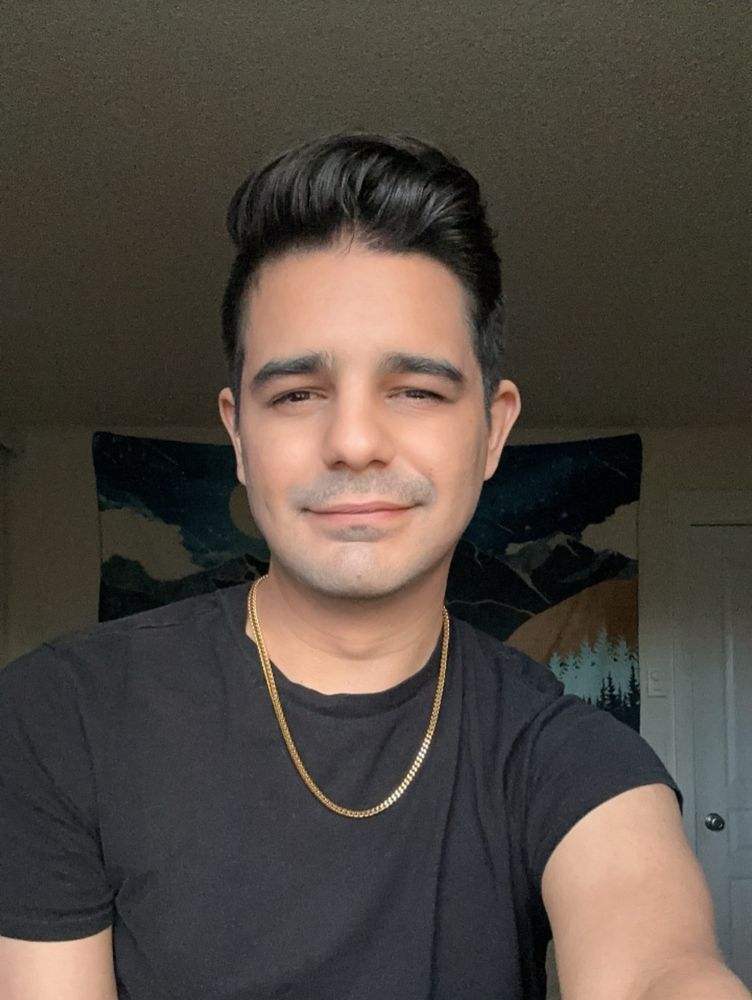 JJ takes a selfie with his gold chain and black shirt 
