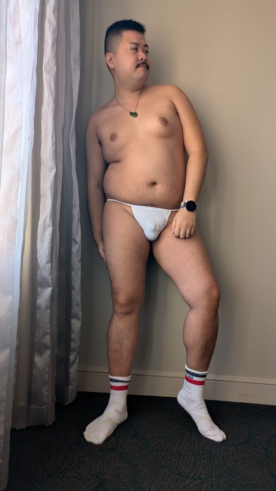 BudgyCub wearing a white fundoshi and white socks in a hotel room
