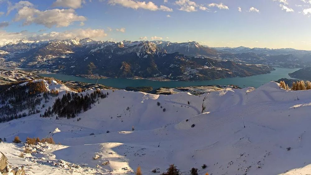 Vue sur le Lac de Serre-Ponçon des pentes enneigées de la Station de Réallon.