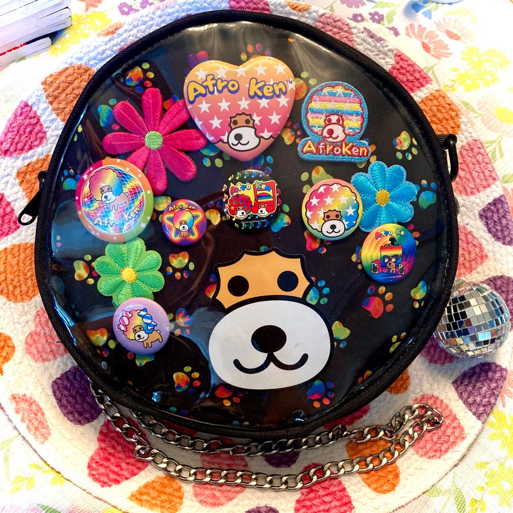 round window bag with merch of san x character afro ken in it 