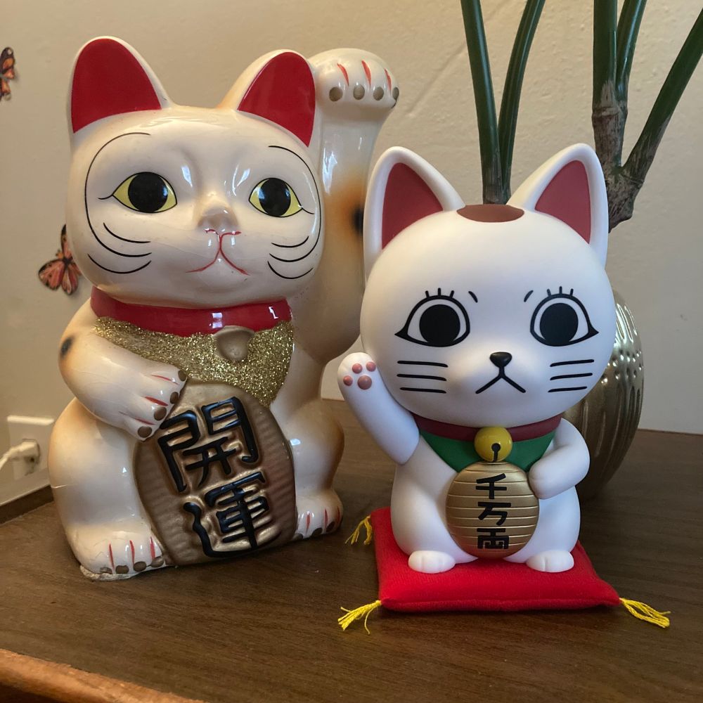 maneki neko and dandadan turbo granny maneki neko on a table