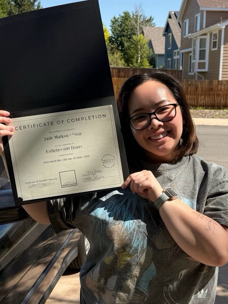 a picture of me holding up my esthetician certificate!