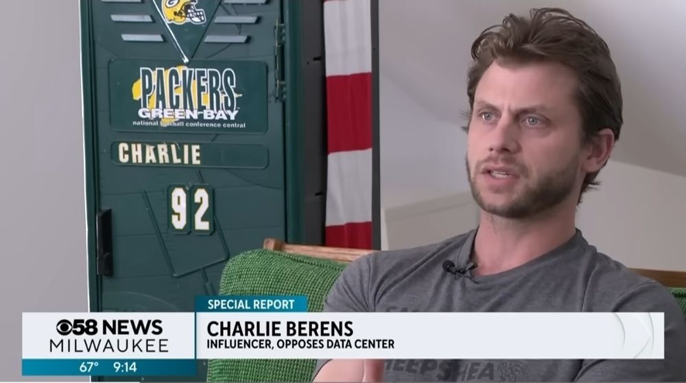 Charlie Berens speaking to the news against AI data centers in front of a kid's Packers locker from the 90s