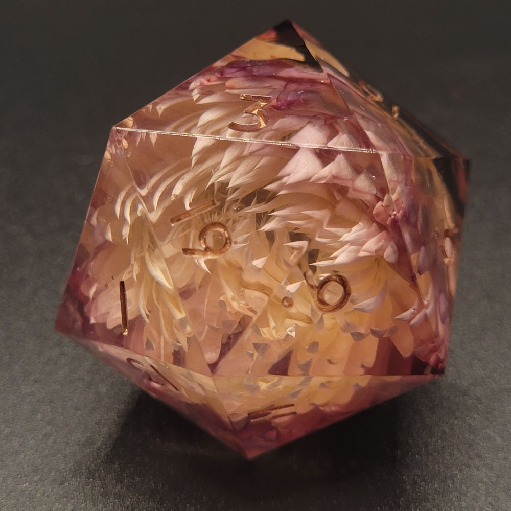 A large handmade dice with a flower inside of it 
