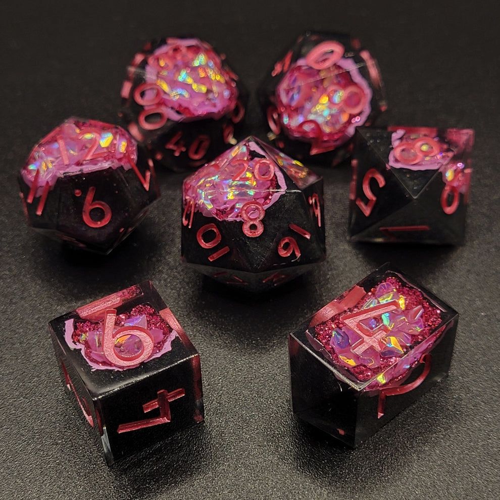 Handmade resin geode dice with black bases and pink glitter inside and metallic pink numbers.