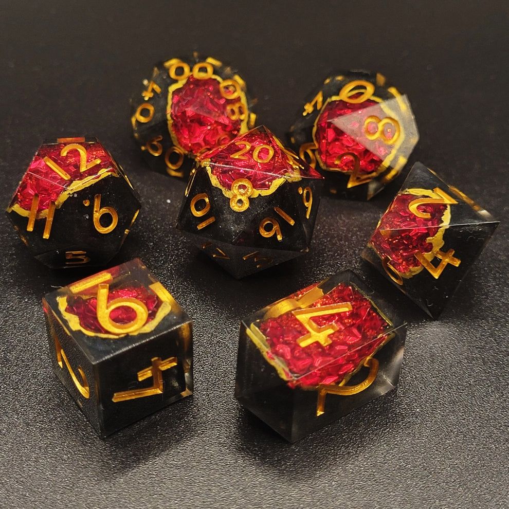 Handmade resin geode dice set with black bases and red glitter inside. Numbers are painted gold.