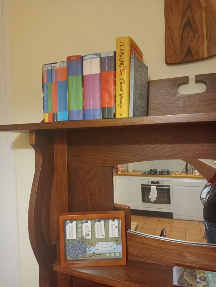 A set of Jowling Kowling Rowling books on a vintage fireplace surround