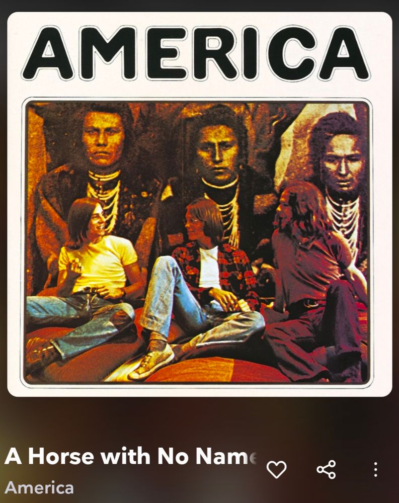 Album cover for the song "A Horse with No Name" by the band America. Shows 3 long haired male musicians in t-shirts and jeans (one is wearing a red and black flannel over his t-shirt). They are sitting in front of a mural that depicts 3 indigenous makes in traditional garb.