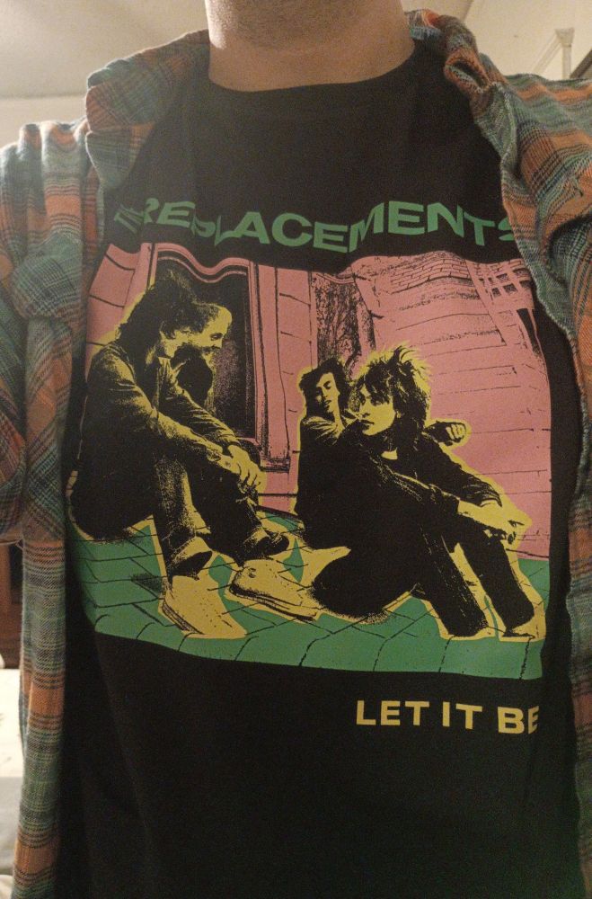 A dapper chap in a pastel neon rendering of an album cover where four hooligans are sitting on a roof outside a window. Above the picture the text reads "The Replacements." Below the picture the text reads "Let It Be."