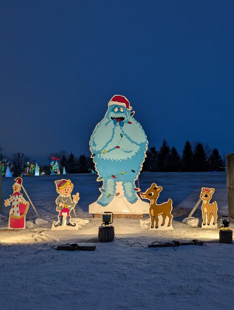 A lit display of the characters from Rudolph the Red Nose Reindeer cartoon with the abominable snowman in the middle.