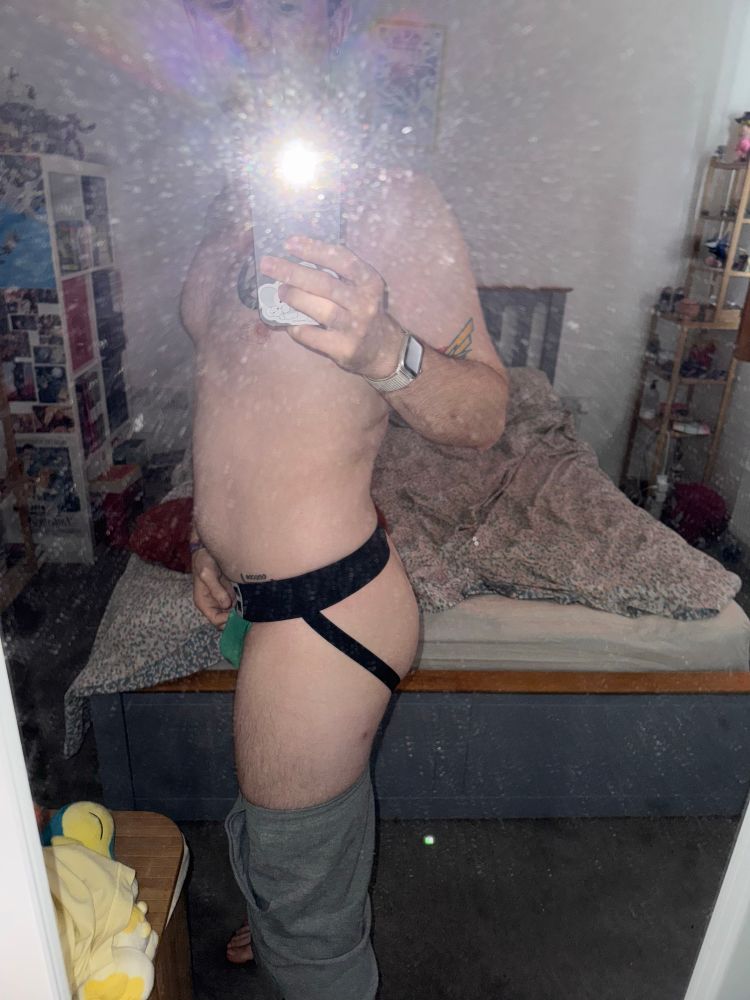 Side view of butt. Messy bed in background 