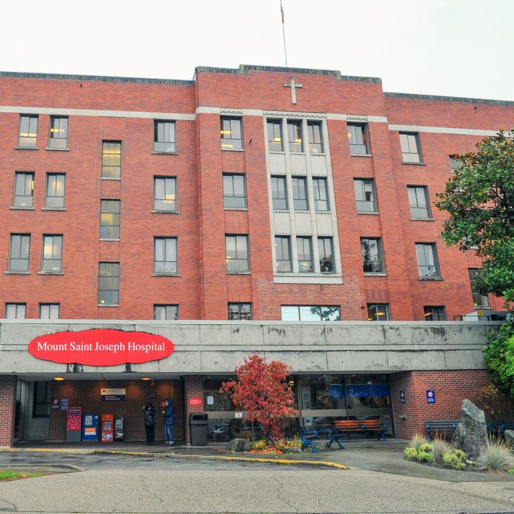 Mount Saint Joseph Hospital's red brick facade with a cross on top and entrance canopy.