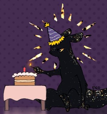 The Gilded sitting next to a small table with a cake. They are holding a lit match and are wearing a birthday hat.