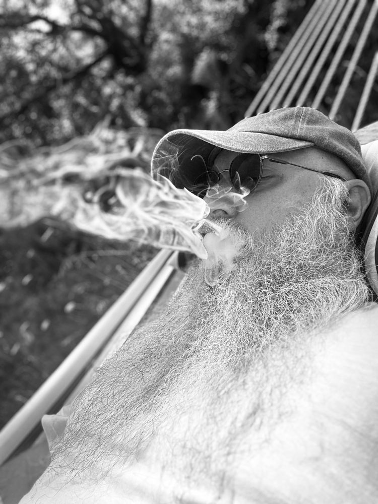 Excalibear blowing a cloud of fragrant cigar smoke while lying in his hammock