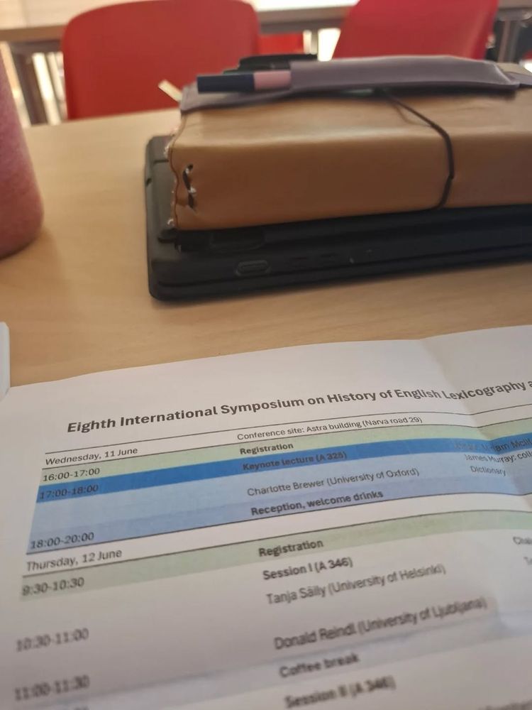 Closeup photo of the ICEHL conference programme and a notebook on a desk.