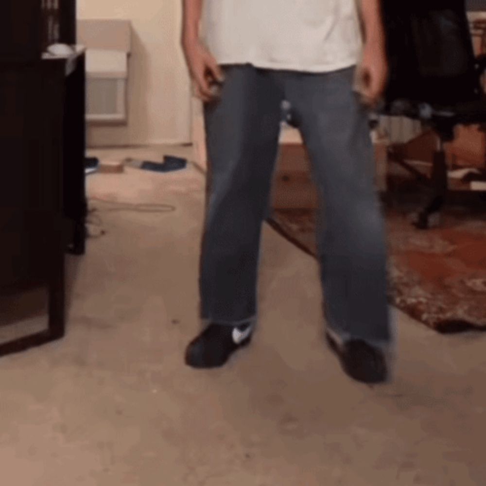 a man standing in a living room wearing nike shoes