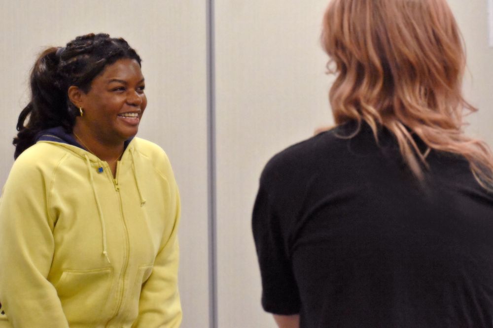 Two actors lean toward each other joyously.