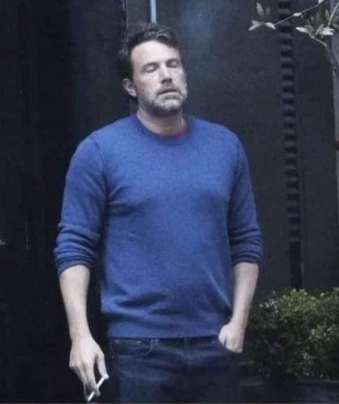 Ben Affleck steht genervt draußen vor einer Tür und raucht eine 