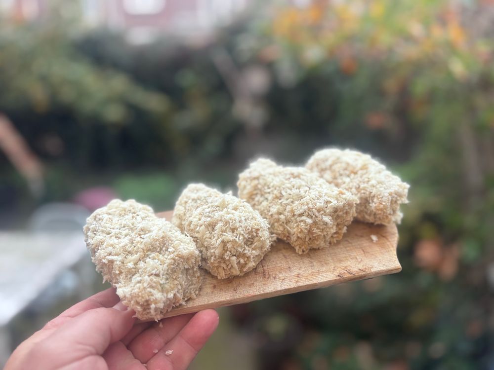 Vier kroketten op een plankje. 