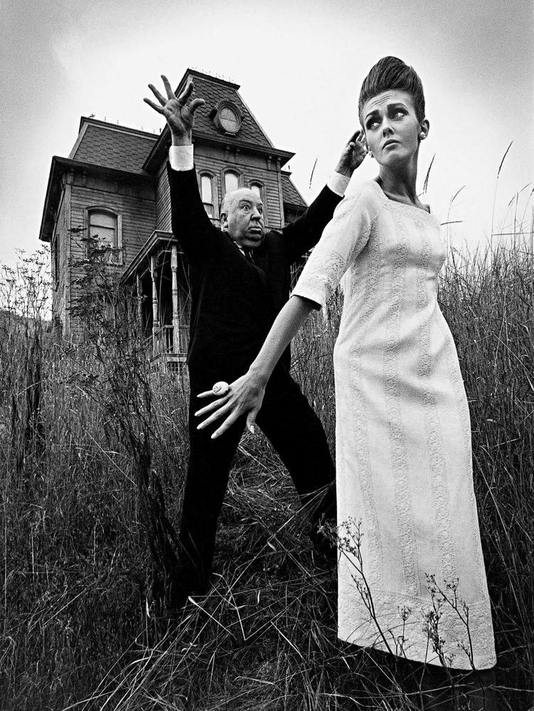 Photograph of Alfred Hitchcock and model Ina Balke posed in front of the PSYCHO house, taken by Jeanloup Sieff for Harper’s Bazaar, 1962.