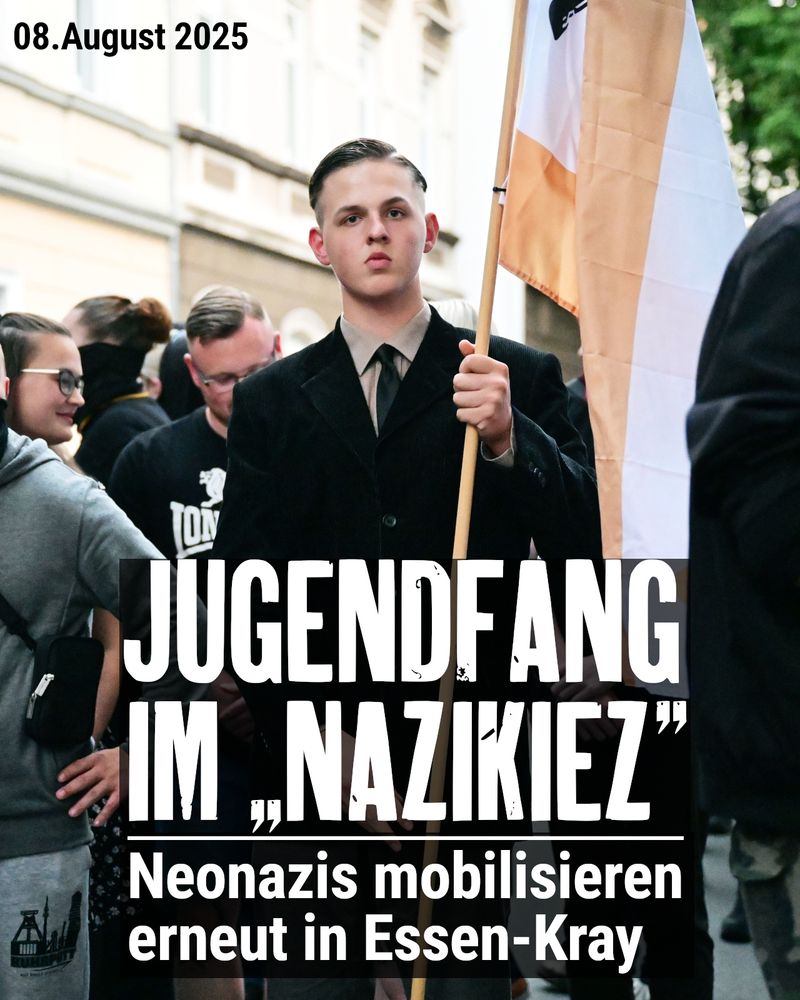 Ein jugendlicher Neonazi trägt Anzug und Krawatte, eine streng zurück gekämmten Seitenscheitel und eine Fahne der Partei "Die Heimat".