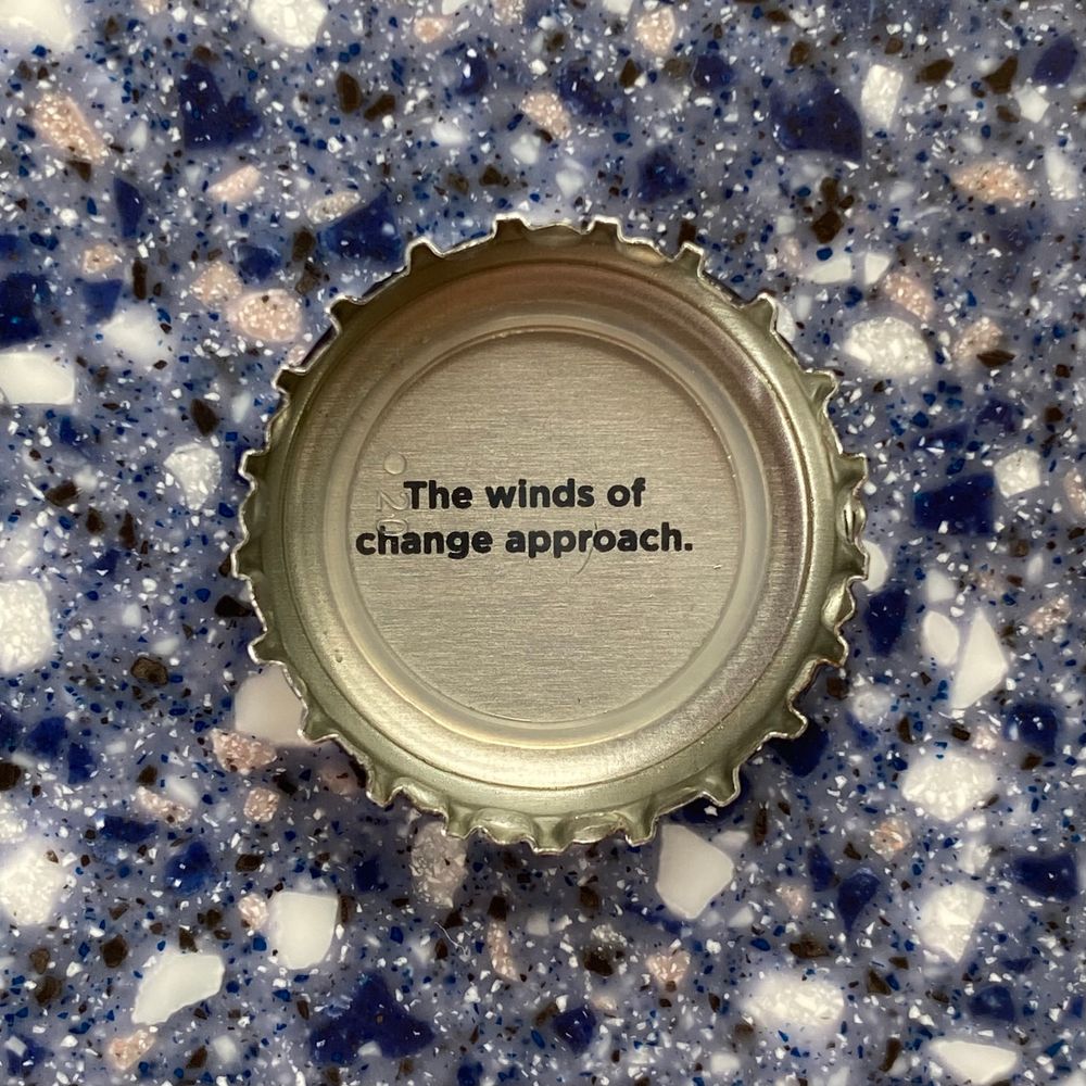 Photo of a bottle cap with the text “The winds of change approach.” printed on it