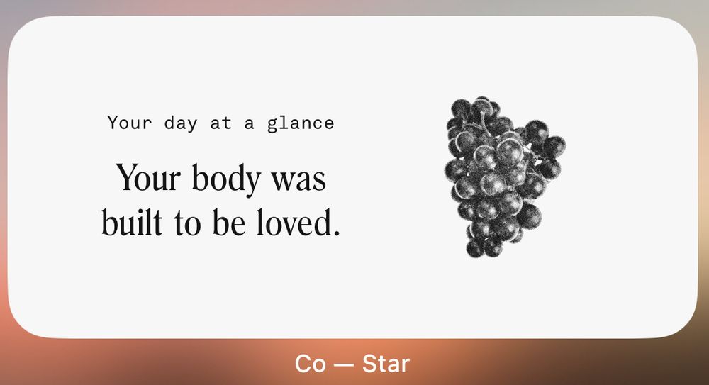 Screenshot of a Co-Star widget that says “Your day at a glance” in small letters toward the top, and “Your body was built to be loved” in larger letters below. There is one bunch of grapes shown in black and white off to the right of the quote